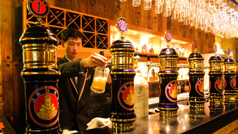 North Korean man pouring beer