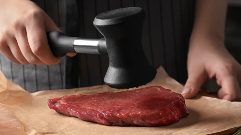 steak being tenderized by mallet