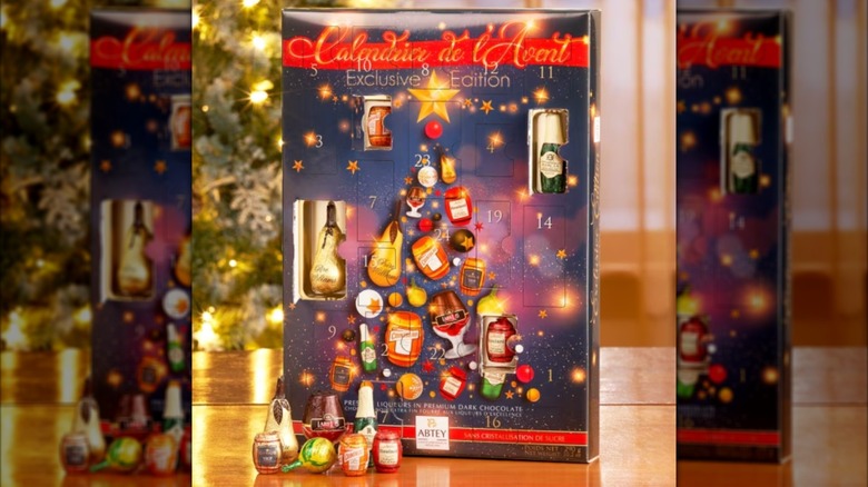 the advent calendar with a few open windows and chocolates placed in front