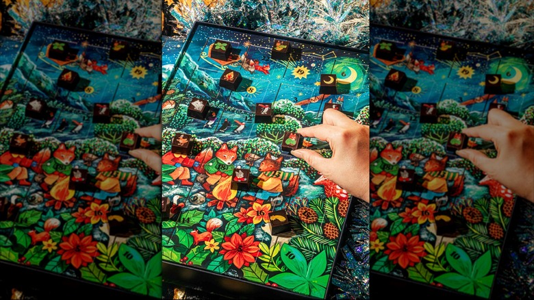 a hand holding a fox-adorned chocolate above the calendar