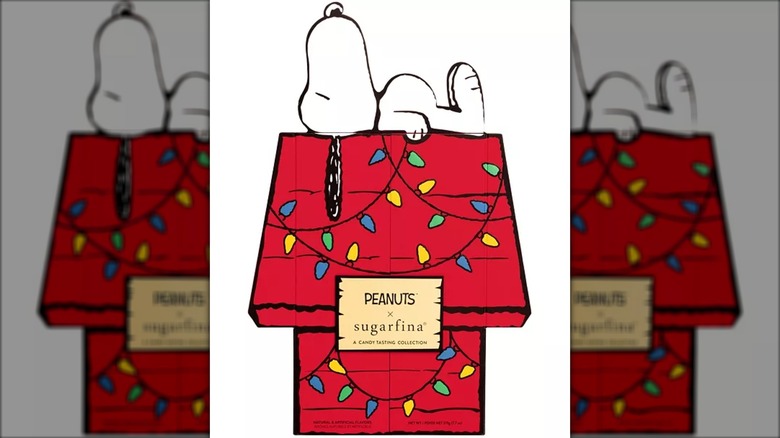 advent calendar front of snoopy lying on top of his red doghouse covered in holiday lights