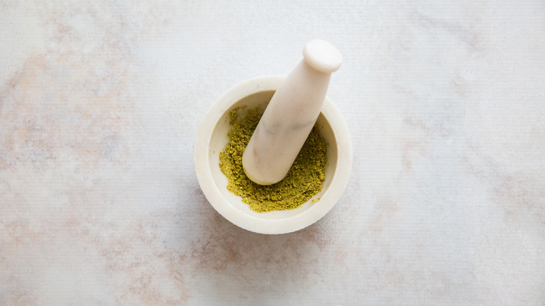 ground pistachios in small mortar