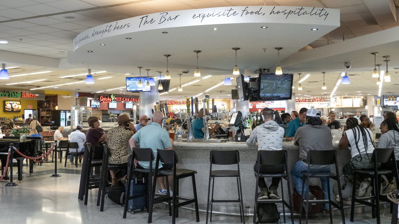 a busy airport food court and bar