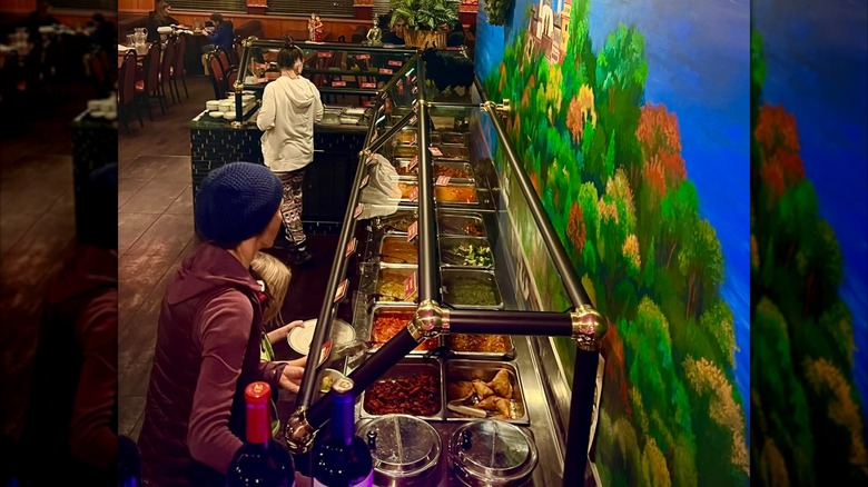 Customers at the buffet in front of colorful mural