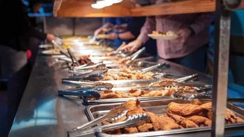 Buffet line with assorted meats and fish filets