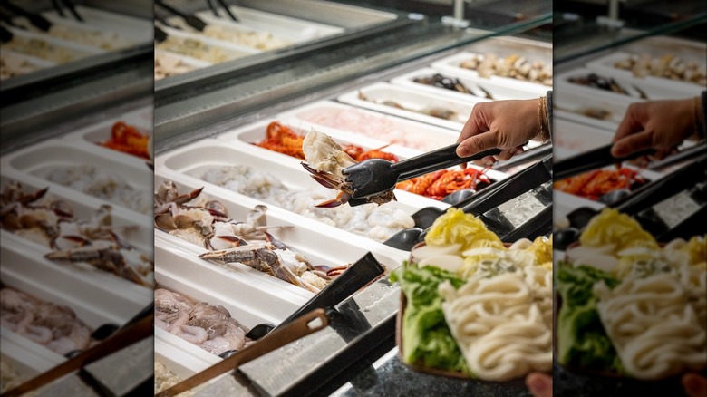 Customer selecting seafood from a buffet line