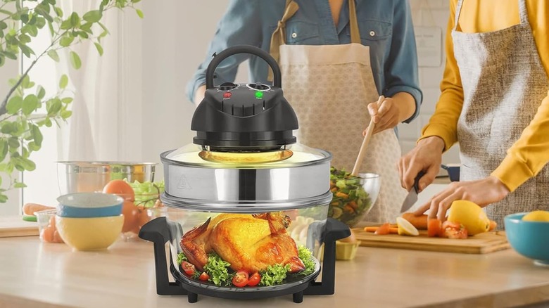 A composite image of the APSARAS USA 10 in1 Glass Air Fryer shown with two people preparing food in the background