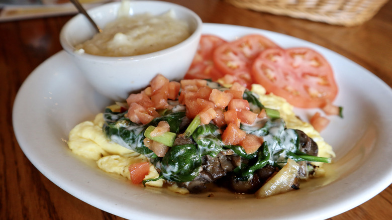 Cracker Barrel Garden Scramble topped with tomatoes, spinach, with cup of grits
