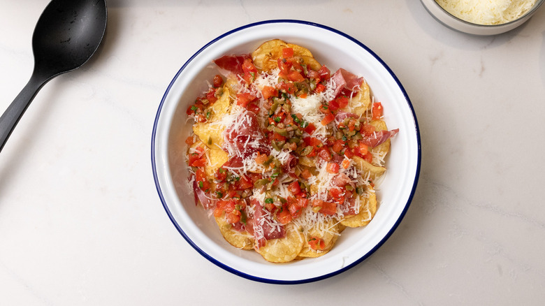 adding toppings to basque nachos