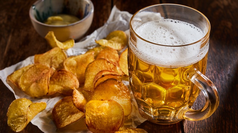 seasoned potato chips  with a light beer in a mug
