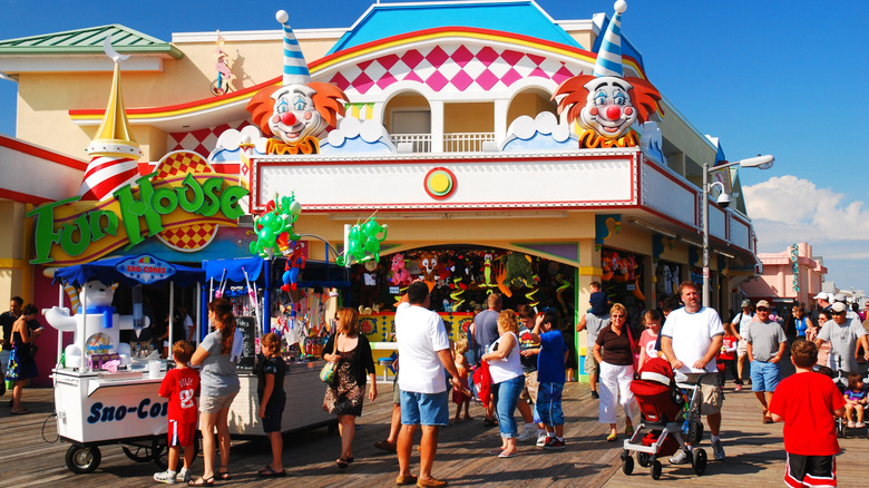 tourists walking by a boardwalk fun house