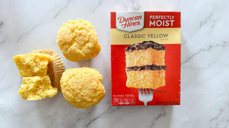 Duncan Hines yellow cake mix and cupcakes on marble surface