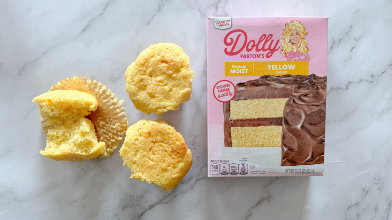 Duncan Hines Dolly Parton cake mix with cupcakes on marble surface