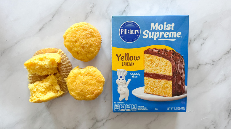 Pillsbury yellow cake mix box and cupcakes on marble