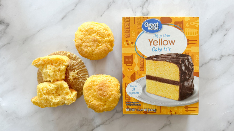 Great Value yellow cake mix with cupcakes on marble surface