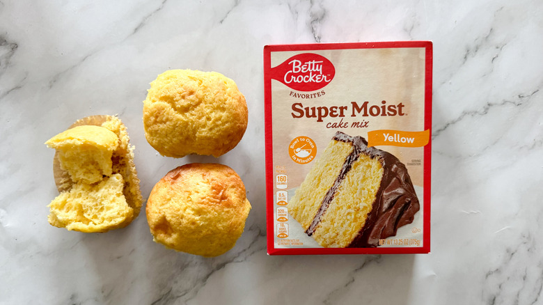 Betty Crocker yellow cake mix and cupcakes on marble surface