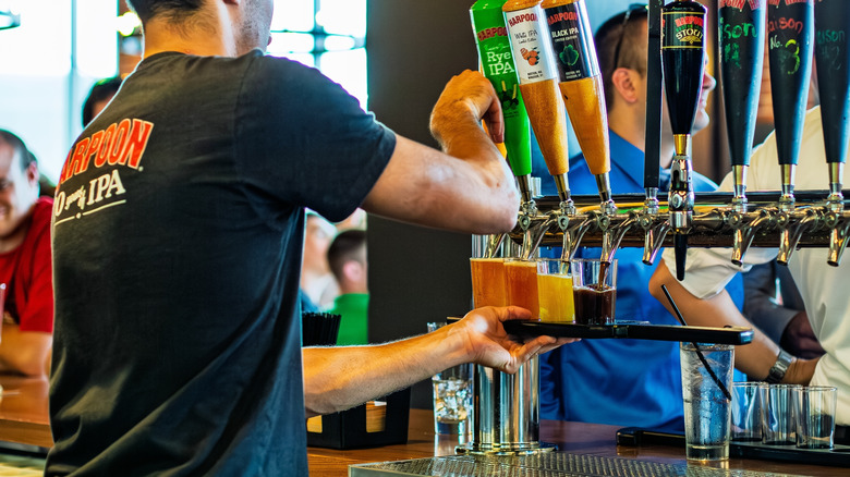 bartender pouring beer into glasses