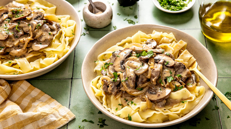 Two white bowls of beef stroganoff on a table