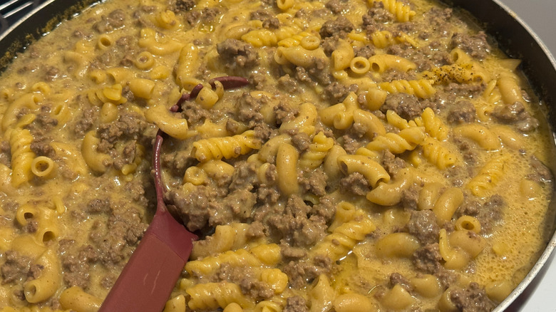 A homemade Hamburger Helper meal cooking in a skillet
