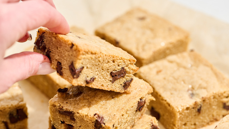 hand lifting blondie off of the stack of blondies