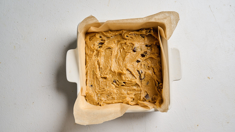 blondie batter smoothed into brownie dish