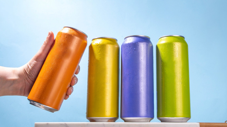 Colorful canned cocktails lined up with a person holding one can