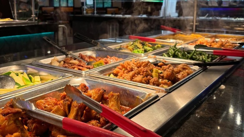 Tongues and filled food trays at Blossom Buffet