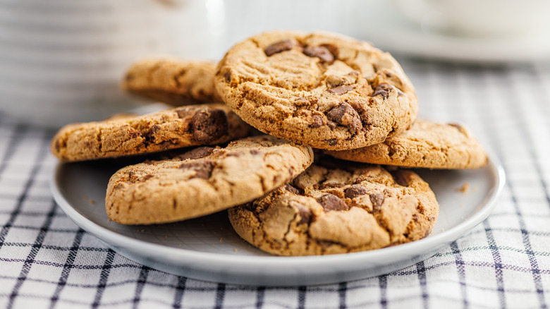 Chocolate chip cookies sitting on a plate and checkered napkin