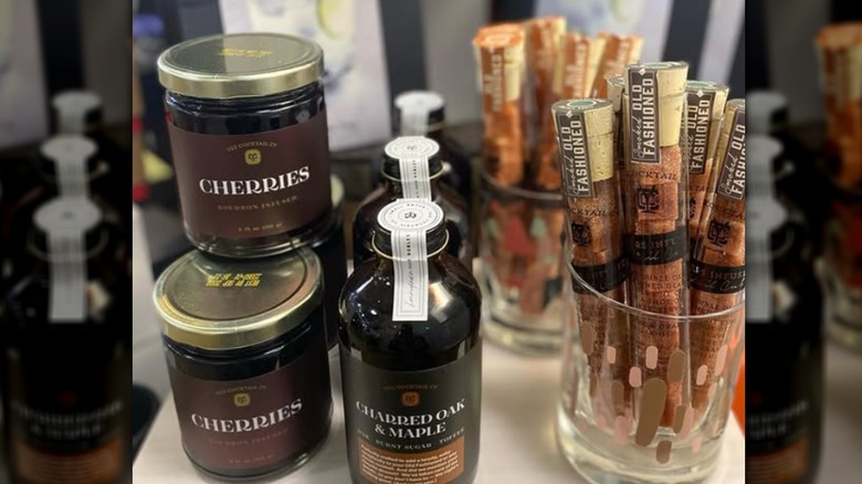 Jars of cherries and bottles on store shelf