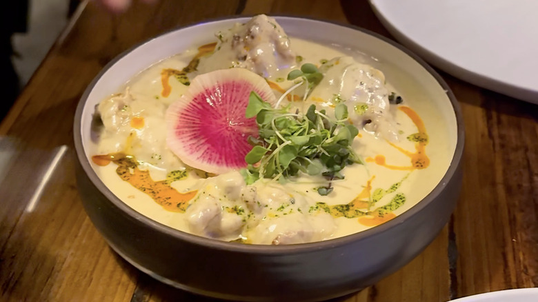 Yellow curry with radish and sprouts on top at Seattle date night restaurant