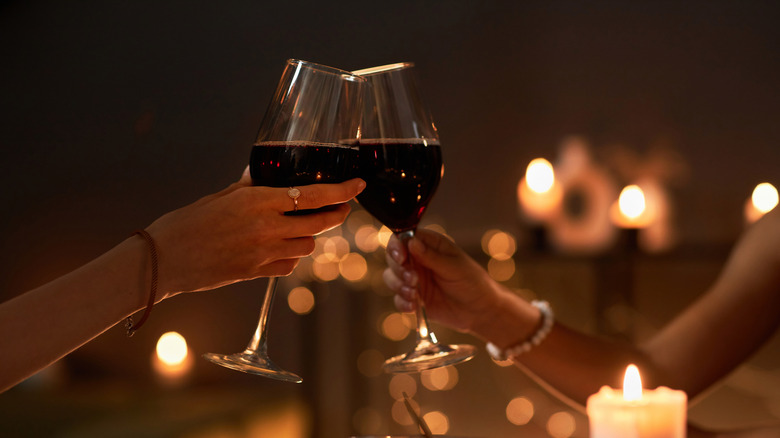 Couple toasting two glasses of red wine on a date night