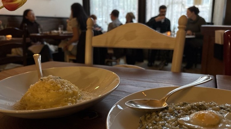 Two bowls of pasta on a wooden table in the dining room of a Seattle date night restaurant