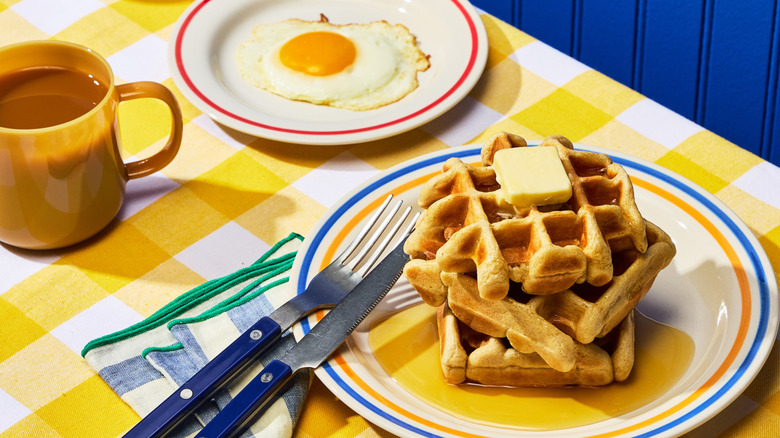 Waffles, egg, and cup of coffee on a table at a diner