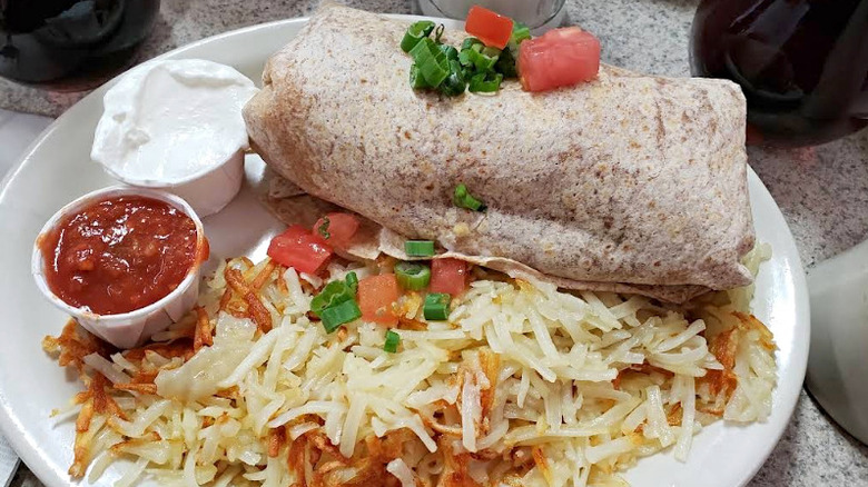 Burrito with red salsa, sour cream, and hash browns at Beth's Café