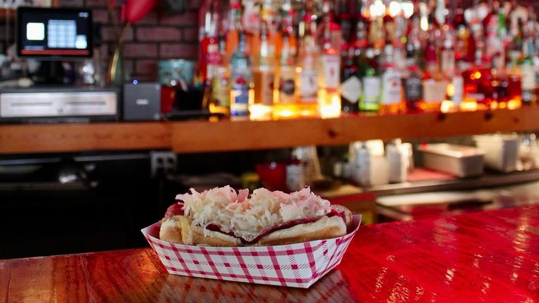 Hot dog in a paper container on the bar top at Larry's