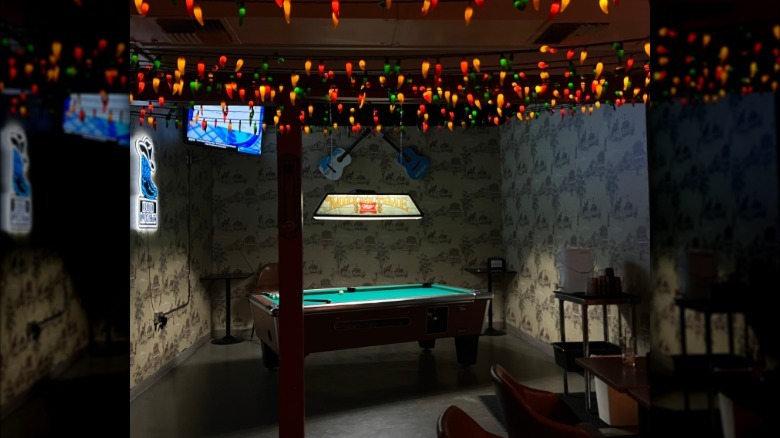 pool table in a dive bar, with christmas lights overhead