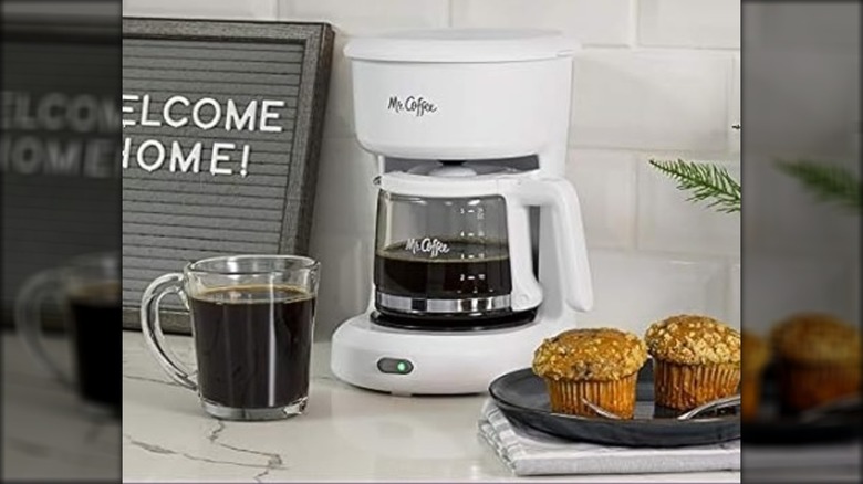 White Mr. Coffee 5-Cup mini brew switch coffee maker with muffins and a mug of coffee