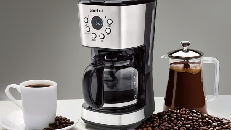 Starfrit programmable drip coffee maker beside cofeee mug, beans, and carafe