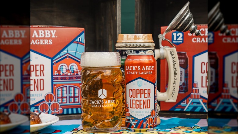 Copper Legend can alongside glass and stein of beer, 12-pack boxes in background