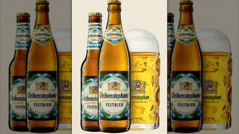 Two bottles of Weihenstephaner Festbier beside full glass with plenty of foam