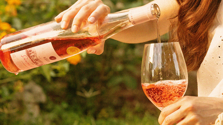 Woman pouring a glass of Ksara Sunset rosé wine