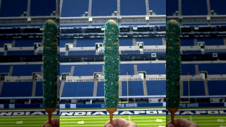 corn dog with ketchup and mustard drizzle on paper