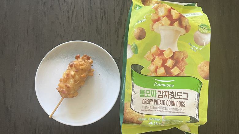 Pulmuone potato corn dog on plate next to the packaging