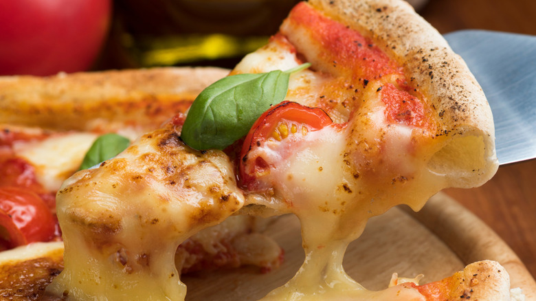 margherita pizza slice lifted with a spatula