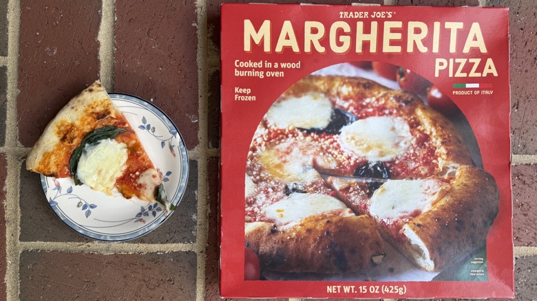 slice of TJ's Margherita pizza on a plate on brick