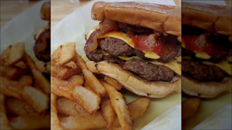 Burger with two patties, bacon, and cheese with fries