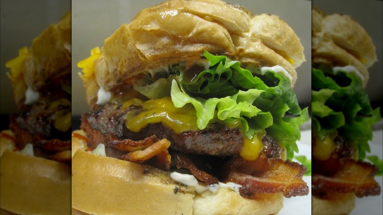 Burger with thick bacon, lettuce, and cheese
