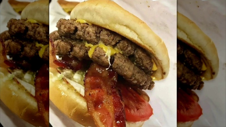 Burger with two patties, bacon, tomato, and cheese