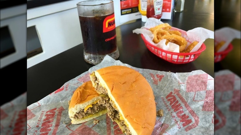 Crumble burger with a glass of root beer and a basket of onion rings