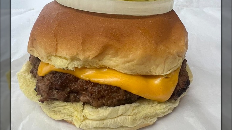 Burger with cheese and an onion on top of the bun